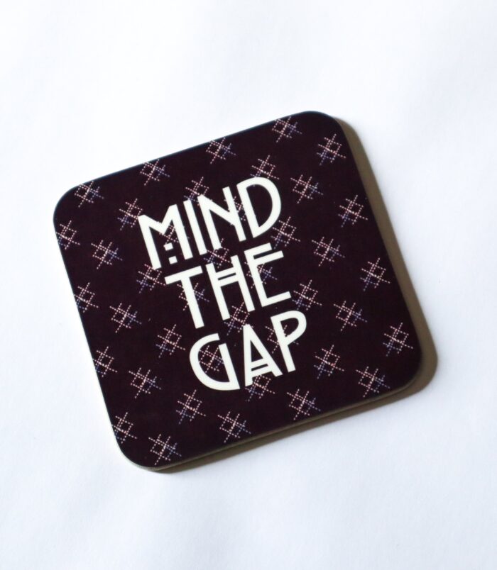 A Scottish coaster inspired by the Scotrail train seats that show the words 'Mind the Gap' in the centre of the coaster. Find more Scottish gifts at Aff Yer Rocket.